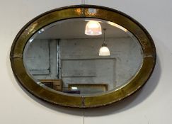 An Arts and Crafts period hammered brass wall mirror, the frame with silvered floral moulded metal