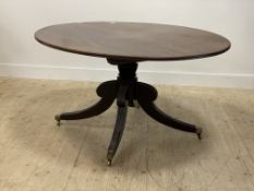 A Regency mahogany tilt top breakfast table, the oval top with boxwood string inlay raised on a