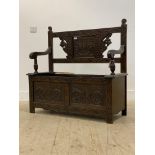 An early 20th century carved oak hall bench, raised on stile supports (A/F) H92cm W108cm, 42cm