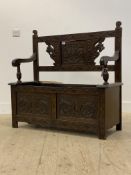 An early 20th century carved oak hall bench, raised on stile supports (A/F) H92cm W108cm, 42cm