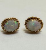 A pair of water opal stud earrings set in claw mounts with rope pattern border, approximately .