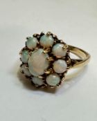A 9ct gold water opal cluster ring, the oval centre stone in claw setting surrounded by eight