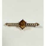An Edwardian 9ct gold bar brooch set central oval cut cognac citrine in claw setting flanked by of