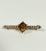 An Edwardian 9ct gold bar brooch set central oval cut cognac citrine in claw setting flanked by of