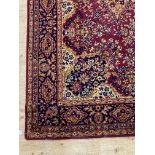 A Persian style rug, the busy red field with medallion and spandrels within a guarded border 363cm x