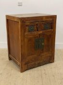 A Chinese elm side cabinet, fitted with two drawers over two panelled cupboards, raised on stile