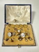 A case containing a collection of gilt metal dress studs, four gilt metal crested studs and a two