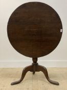 A George III oak snap top tripod table, the circular top over baluster turned column and triple