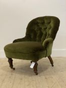 A Victorian walnut button back slipper chair, upholstered in green velvet, raised on turned supports