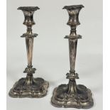 A pair of late 19thc Sheffield plate weighted candle sticks of tapered form with C scroll and