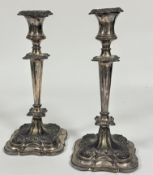 A pair of late 19thc Sheffield plate weighted candle sticks of tapered form with C scroll and