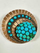 A Continental rose metal circular panel radiating brooch the centre set ten graduated turquoise