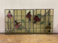 An early 20th century stained and lead glazed window comprising four panels, each decorated with