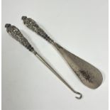 An Edwardian Birmingham silver handled shoe horn and matching button hook with rococo style chased