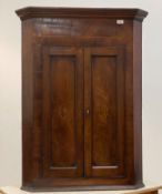A Georgian inlaid mahogany wall hanging corner cupboard with twin doors enclosing shelves, H106cm,