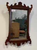 An Edwardian mahogany framed fret cut wall hanging mirror, with carved gilt slip 57cm x 38cm