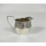 An Edwardian Birmingham silver milk jug with s shaped handle and gadroon scalloped top and chased