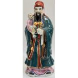 A large modern Chinese porcelain figure of a Daoist immortal with lingzhi/ruyie and child, gilt with
