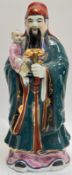 A large modern Chinese porcelain figure of a Daoist immortal with lingzhi/ruyie and child, gilt with