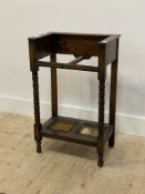 An early 20th century oak two division stick stand, with bobbin turned columns and original drip