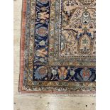 A Hand knotted Persian rug, the pale field with repeating design within a guarded blue border