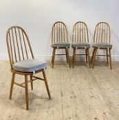 A set of four mid century oak dining chairs by Priory, in the Ercol style, hoop and spindle back