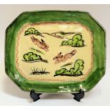 An earthenware press moulded studio pottery slipware dish with incised decoration of bunny