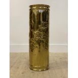 A gilt hammered brass stick stand of cylindrical outline, decorated with grapes and vine leaves