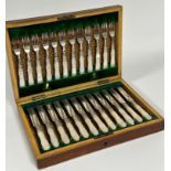 An Edwardian mahogany canteen containing twelve pairs of engraved Epns fruit knives and forks.