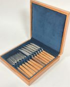 A set of six pairs of Mills Moore stainless steel teak handled steak knives and forks in fitted teak
