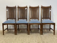 A set of four stained hardwood dining chairs, with spar backs above overstuffed seats covered in Art