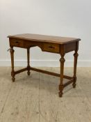 A polished pine knee hole desk, late 20th century, with serpentine top over two drawers, raised on