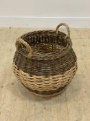 A twin handled wicker log basket of compressed cylindrical form, H47cm