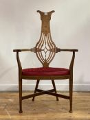An Arts and Crafts period oak elbow chair, the marquetry, shaped and pierce carved splat back over