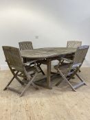 A silvered teak garden suite, comprising an extending garden table, the slatted oval top with