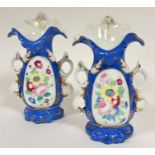 A pair of 19thc Continental porcelain flower vases in the rococo taste with scrolling tops and