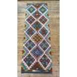 A Chobi kilim runner rug of repeating lozenge design. 208cm x 64cm