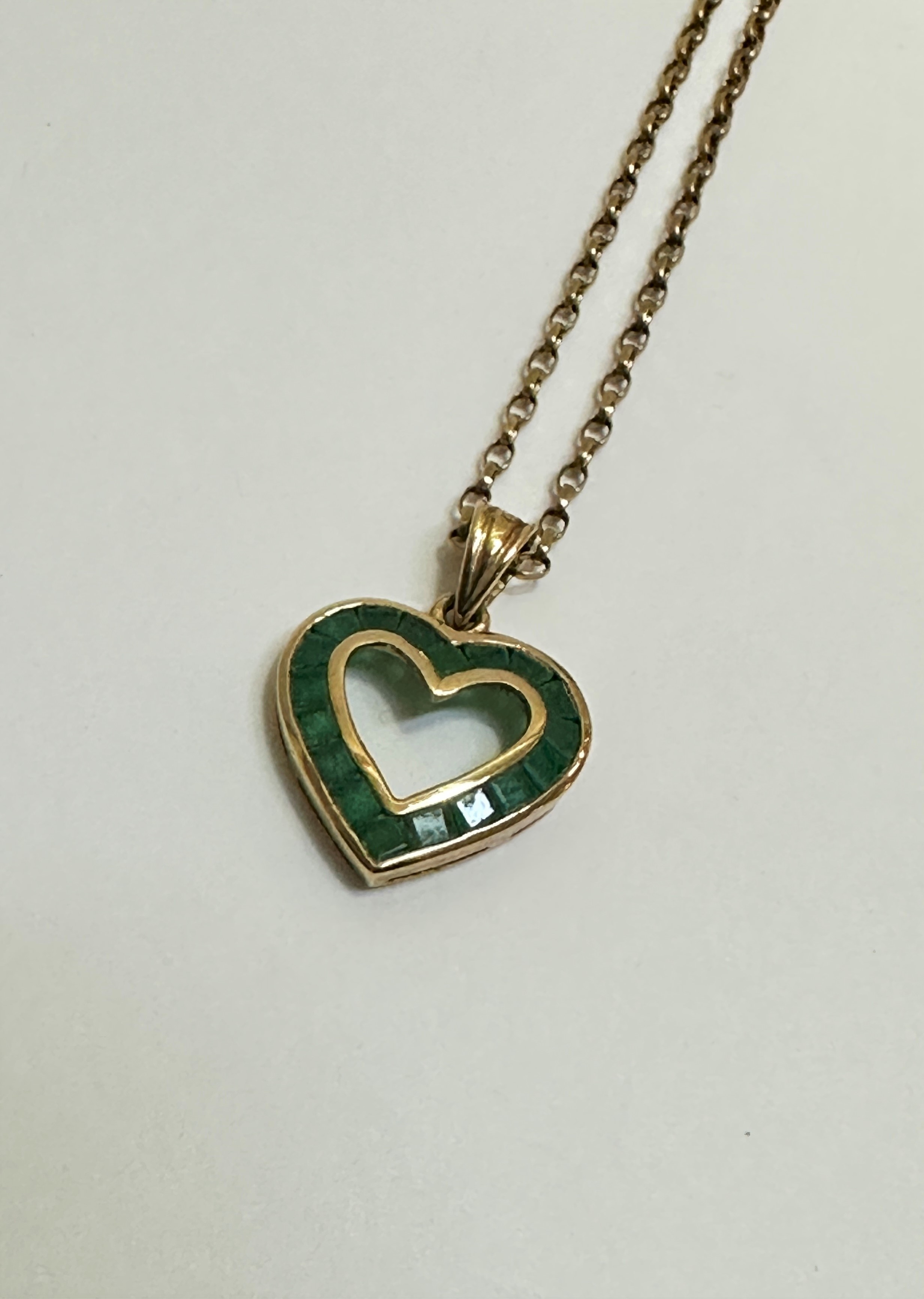 A 9ct gold open work heart shaped pendant set eighteen calibre set emeralds mounted on trace link - Image 2 of 3