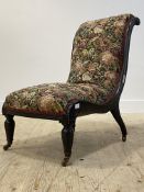 A Victorian ebonised nursing chair, with scrolled show frame, needlepoint upholstery worked in a
