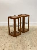 A pair of Danish mid century teak end or bedside tables, each with panelled top over adjustable