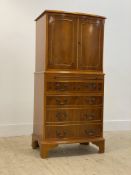 A reproduction yew wood cocktail cabinet in the form of a miniature bow front linen press, twin