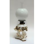 A Moore Brothers figural oil lamp decorated with three cherubs holding the body decorated with