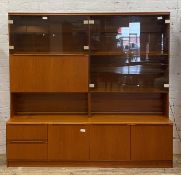A mid century teak wall display cabinet, with a combination of smoked glass doors enclosing