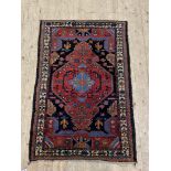 A hand knotted Persian Hamadan design rug, with a dark abrashed field and bordered 127cm x 84cm