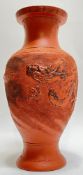 A Japanese Tokoname redware baluster vase with low-relief dragon decoration against a stippled