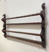 A Victorian style carved mahogany two height delft rack, the panel ends carved with lion and swan