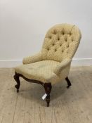 A Victorian button back slipper chair, upholstered in faded yellow cotton, raised on cabriole