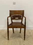 A hardwood elbow chair of Georgian inspiration, with pierce carved panelled back and reeded turned