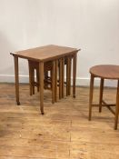A mid century teak nest of tables, the larger on castors, with four smaller drop leaf tables