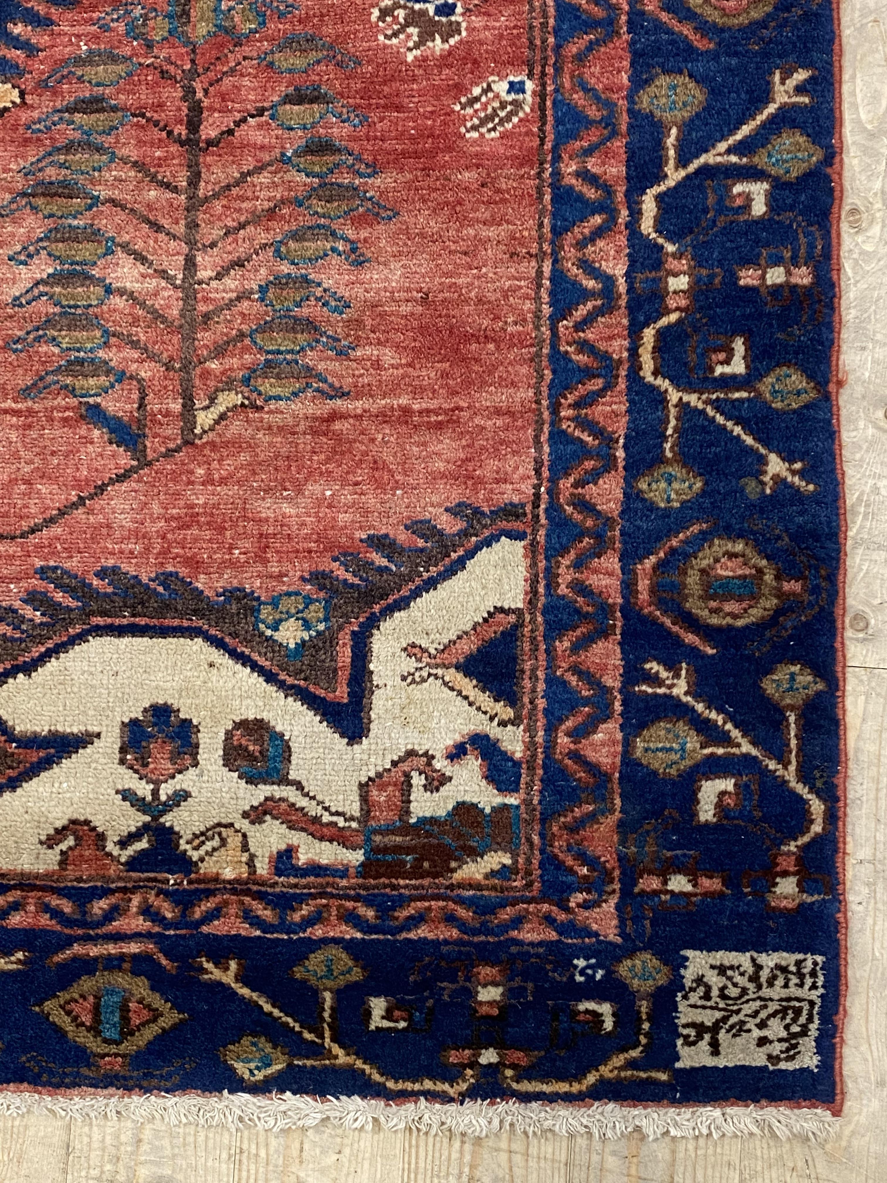 A hand knotted Persian Hamadan design rug, the red field with medallion, botehs, and ivory spandrels